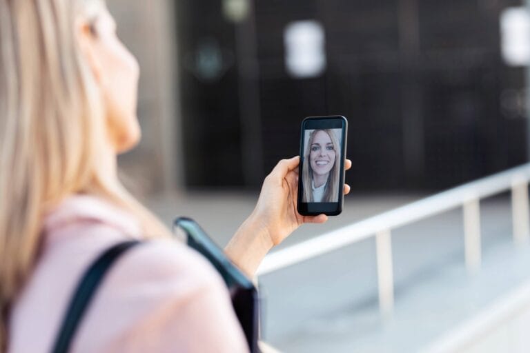 Woman holding a smartphone displaying a smiling face, symbolizing digital identity and mobile communication. Critical for enterprises, MSSPs, and security professionals in the United States combating cyber attacks and AI deepfake attacks delivered via smishing and text messages. Checktxt provides advanced solutions for verifying digital identities, detecting deepfake threats, and securing text-based communications. #Checktxt #AIDeepfake #SmishingAttacks #Cybersecurity #DigitalIdentity #TextMessageSecurity #EnterpriseSecurity #MSSP #Developers #ProductManagement #UnitedStates